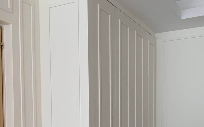 Dressing sur mesure en bois laqué avec portes moulurées à Paris